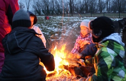 Kinder am Lagerfeuer in Winterlandschaft